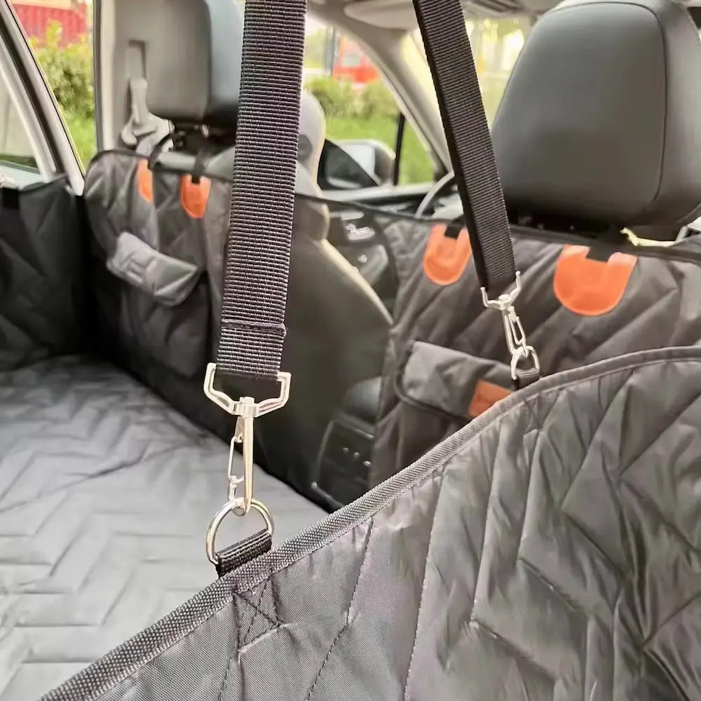 Perro tranquilo en el asiento trasero del coche sobre una funda protectora